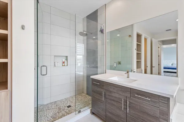 a bathroom with a shower sink and mirror