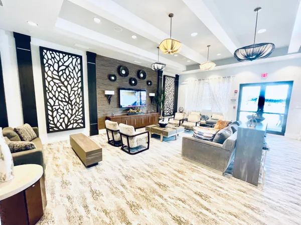 a living room with furniture kitchen view and a chandelier