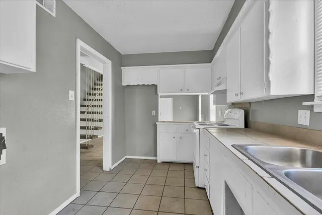 a kitchen with a sink a refrigerator and cabinets