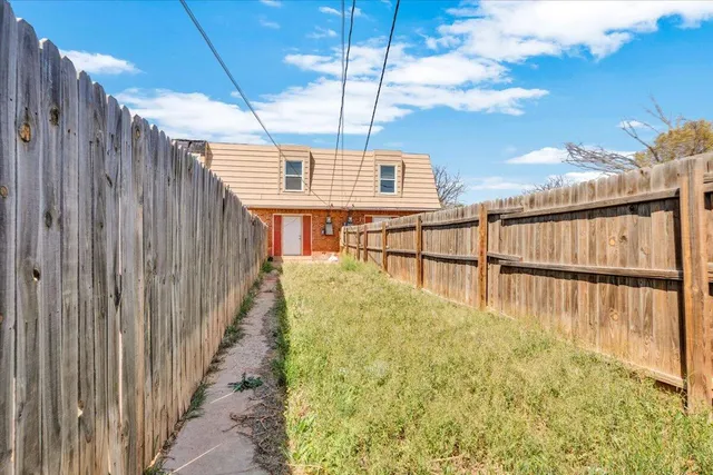 a view of a chair and table in the backyard