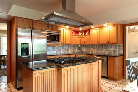 a kitchen with kitchen island granite countertop a sink and cabinets