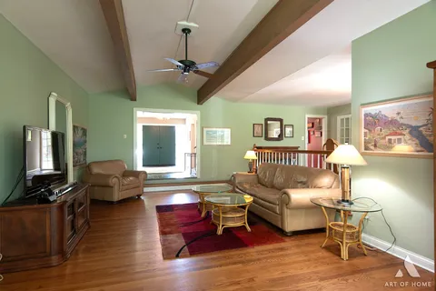 a dining room with furniture a chandelier and wooden floor