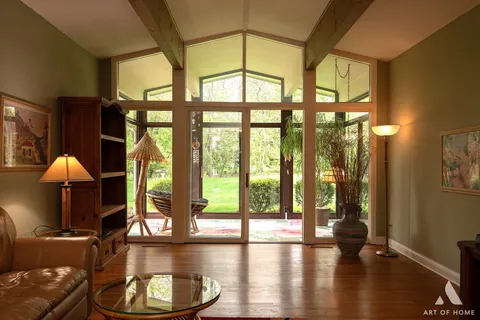 a view of a room with wooden floor and a floor to ceiling window