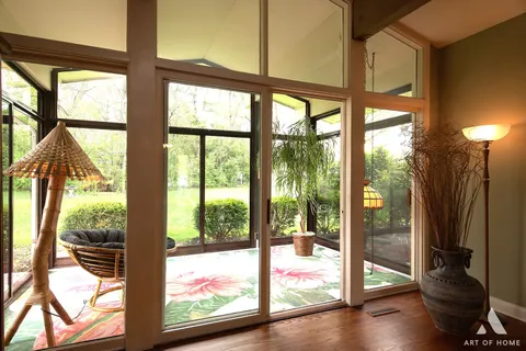 a living room with patio furniture and a floor to ceiling window