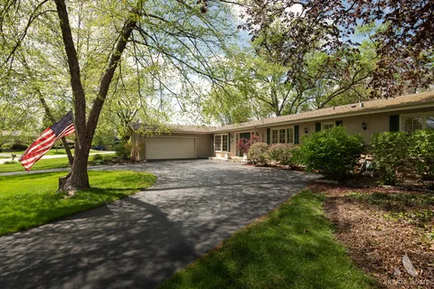 a view of a house with a yard and tree s