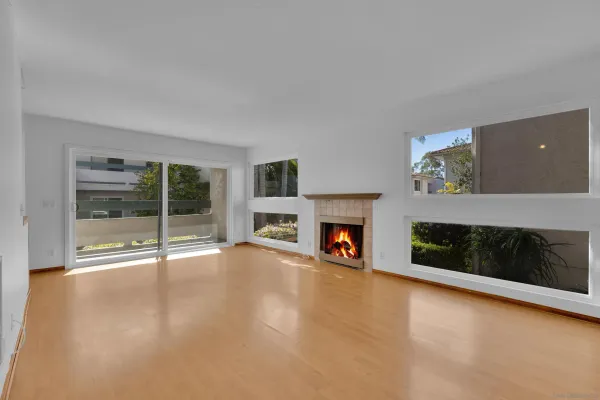 a view of an empty room with a fireplace and window