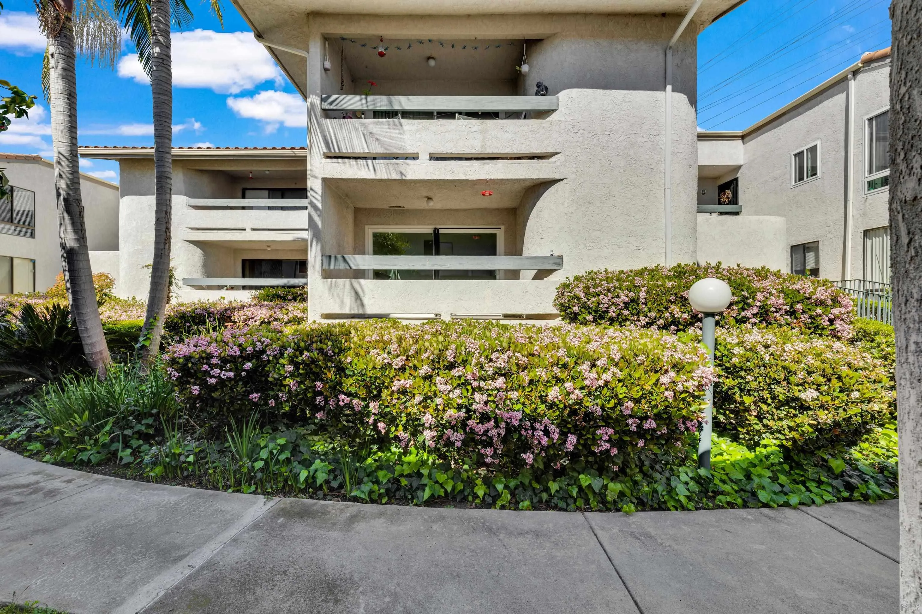 2308 Altisma Way, Unit 118 Carlsbad, CA 92009 - Photo 17 of 51 a front view of a house with a garden