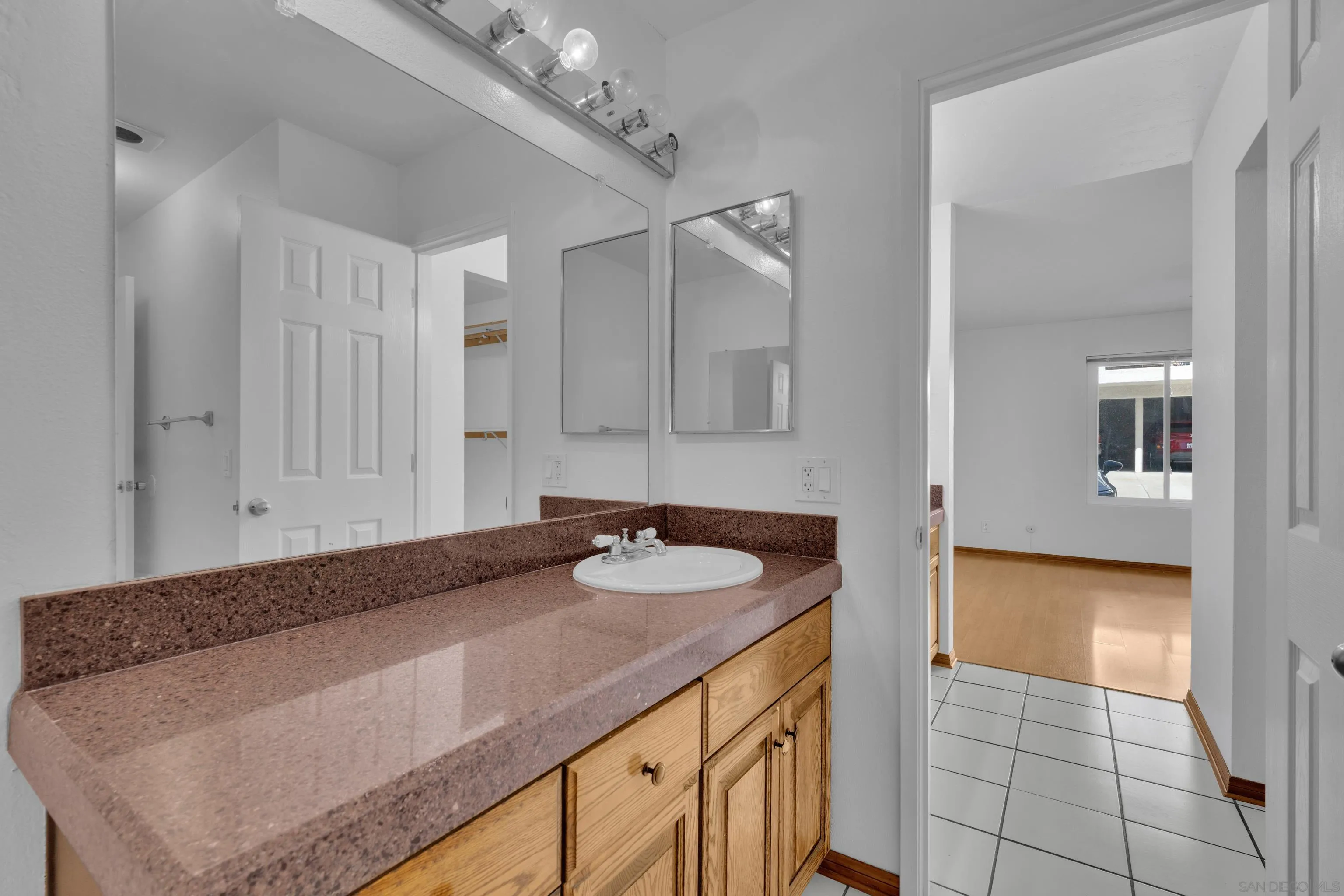 2308 Altisma Way, Unit 118 Carlsbad, CA 92009 - Photo 37 of 51 a bathroom with a granite countertop sink and a mirror