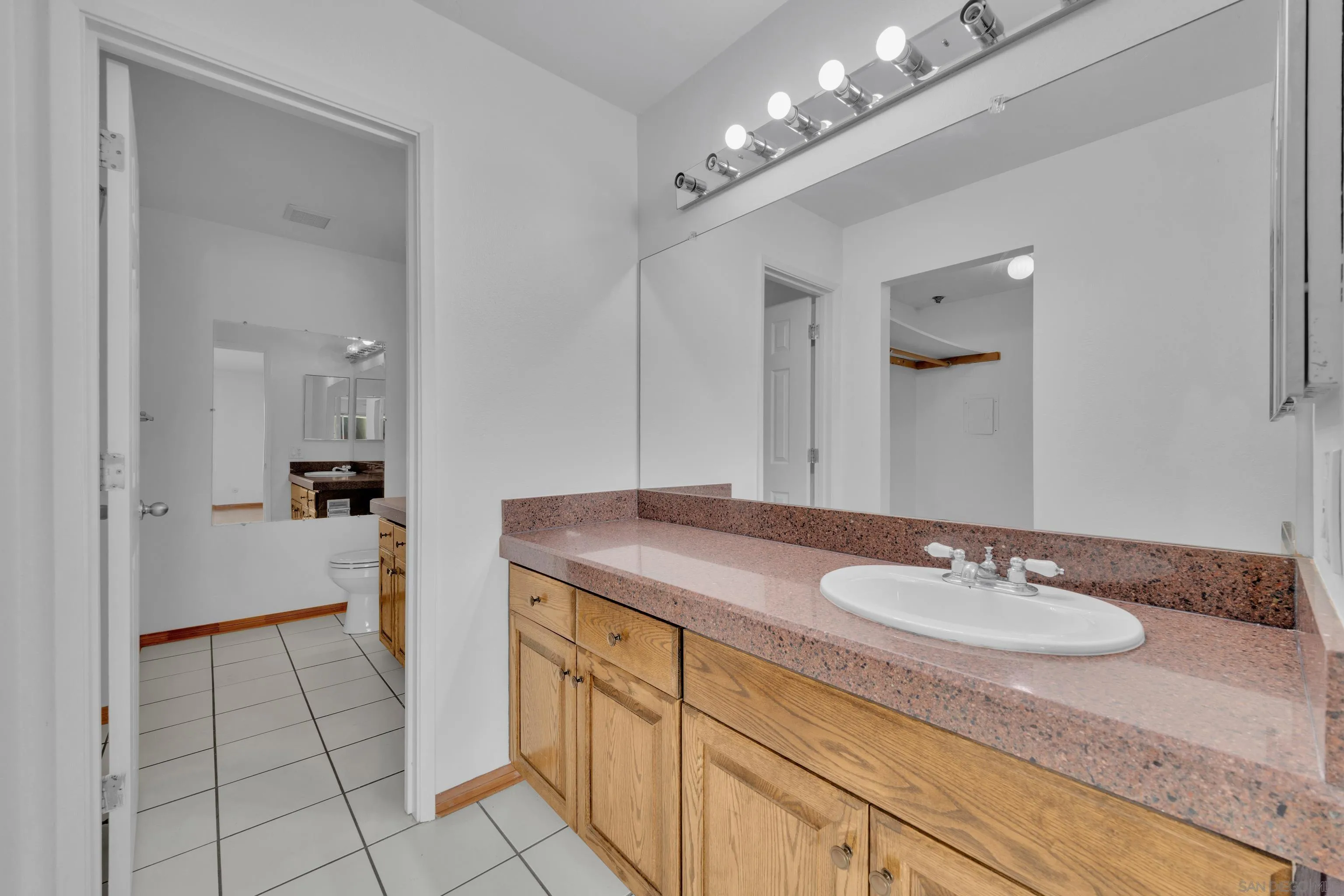 2308 Altisma Way, Unit 118 Carlsbad, CA 92009 - Photo 40 of 51 a spacious bathroom with a granite countertop sink a mirror and a shower