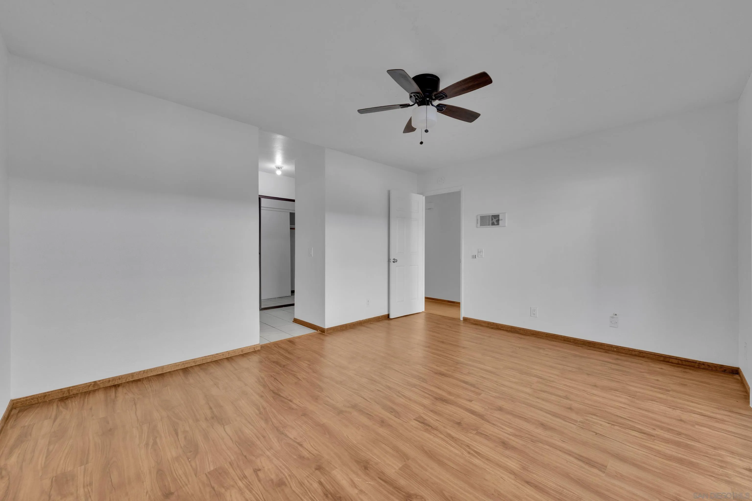 2308 Altisma Way, Unit 118 Carlsbad, CA 92009 - Photo 46 of 51 a view of an empty room with wooden floor and a ceiling fan