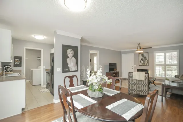 a living room with furniture two window and wooden floor