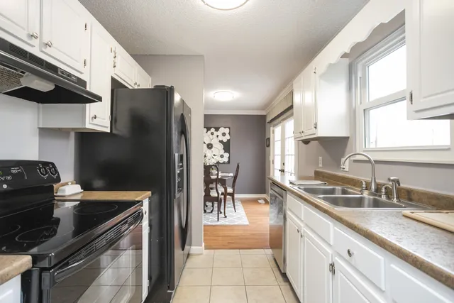 a kitchen with granite countertop a refrigerator stove and sink