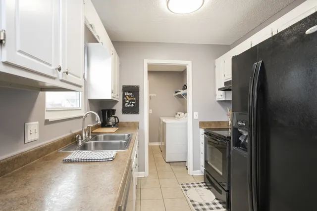a kitchen with stainless steel appliances granite countertop a sink a refrigerator and a stove