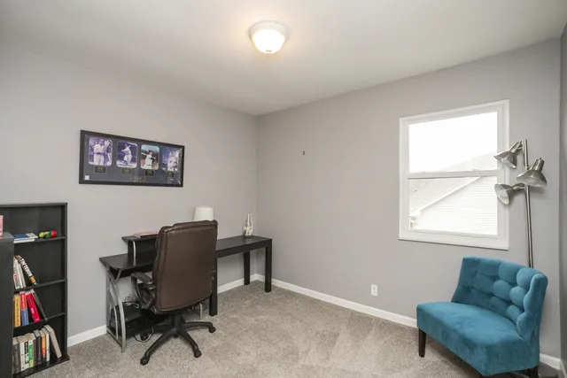 a view of a workspace with furniture and a window