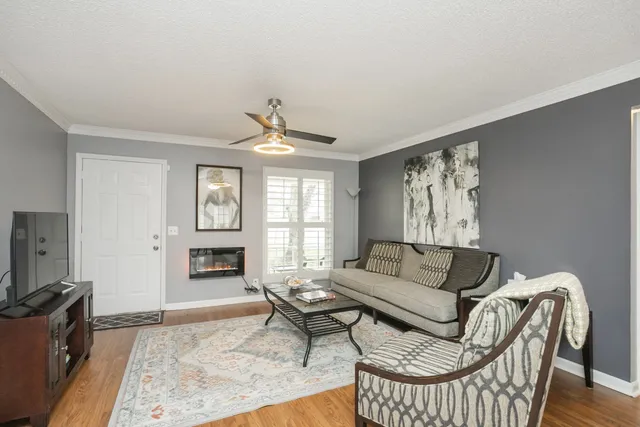 a living room with furniture a flat screen tv and a window