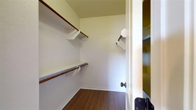 a view of a room with wooden floor and a ceiling fan