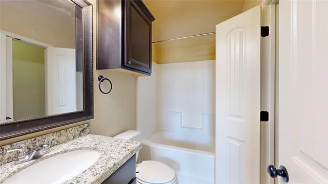a view of an empty room with wooden floor and a ceiling fan