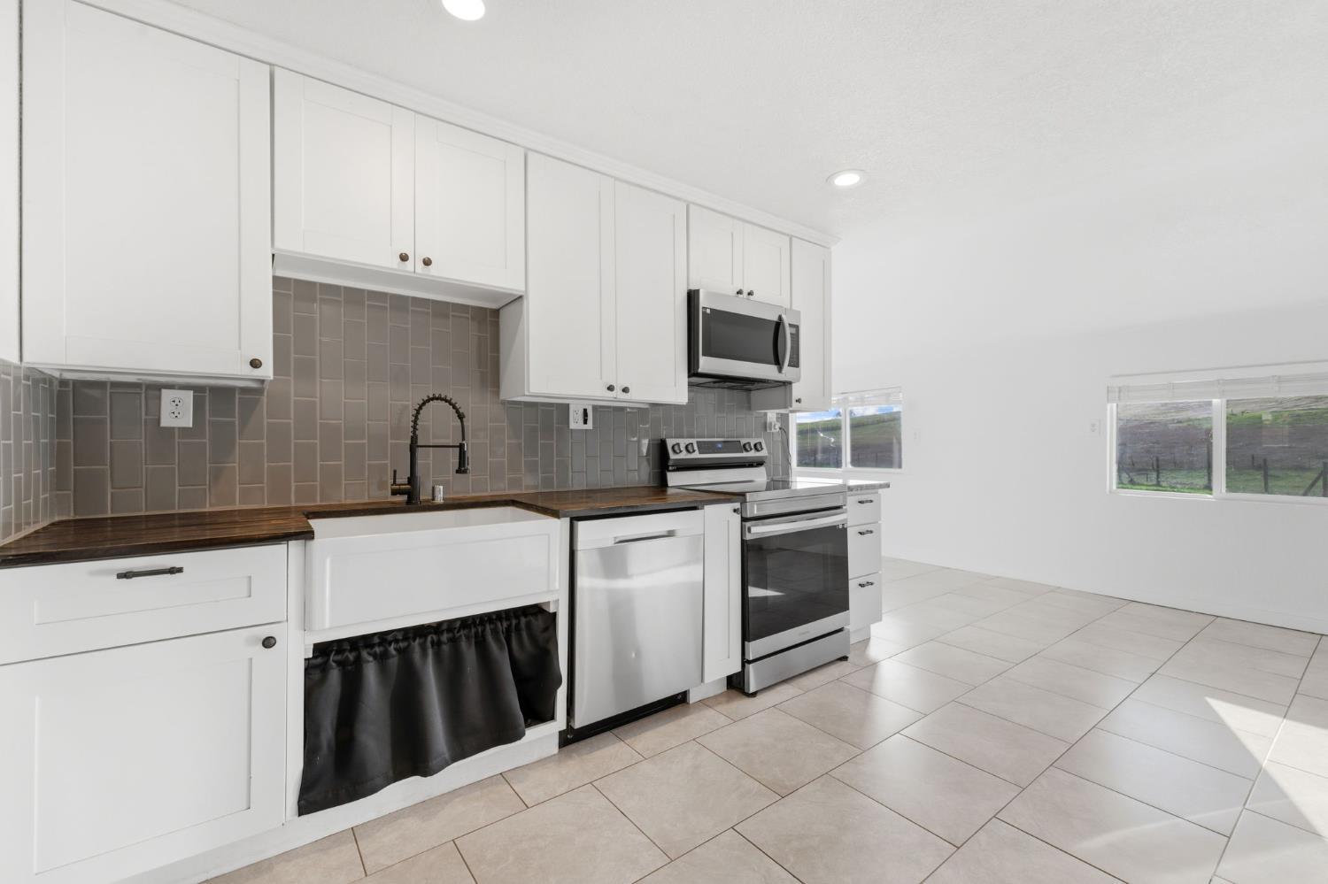 a kitchen with appliances a sink and cabinets