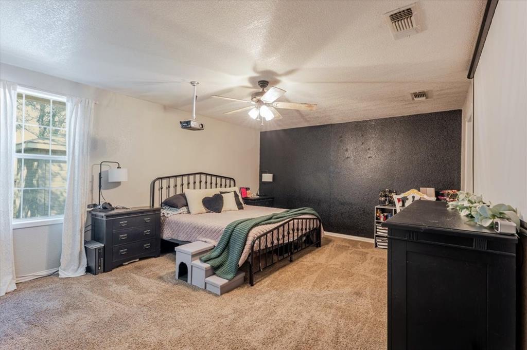 2350 Grindstone Road Millsap, TX 76066 - Photo 12 of 33 a bedroom with a bed and a chandelier