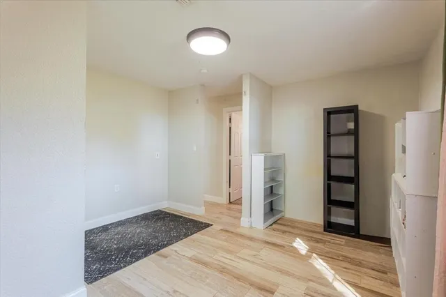 a view of an empty room with closet and a window