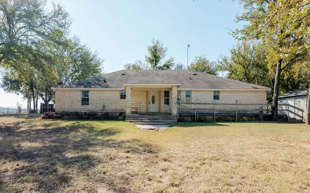 a front view of a house with a yard and trees