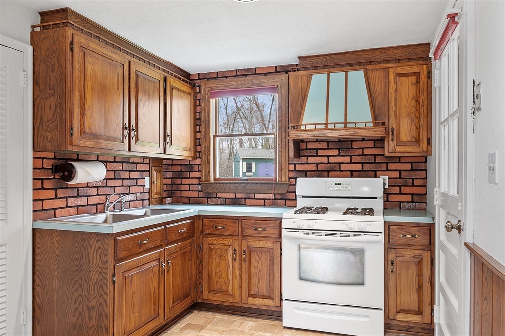 40 Elizabeth Road Billerica, MA 01821 - Photo 7 of 42 a kitchen with stainless steel appliances granite countertop a stove a sink and a microwave