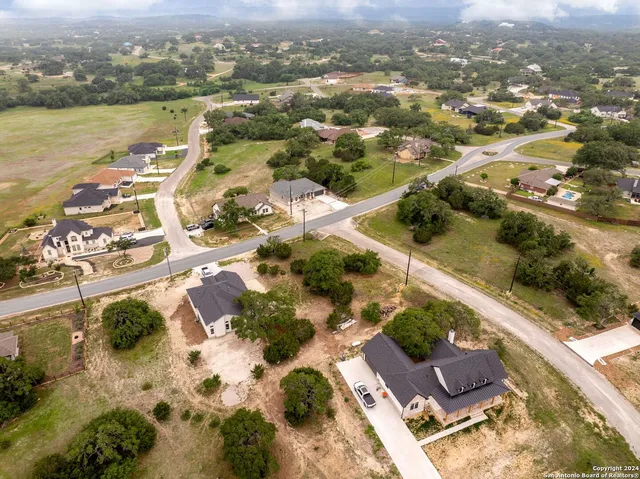 an aerial view of ocean and residential houses with outdoor space