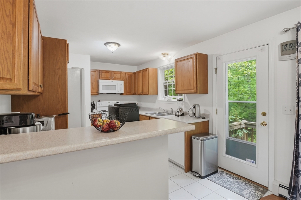 186 Common Street Groton, MA 01450 - Photo 9 of 28 a kitchen with a sink a stove and cabinets