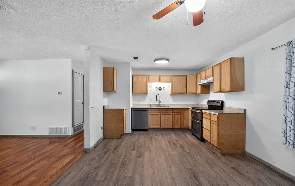 604 Fegan Street Weatherford, TX 76086 - Photo 15 of 36 a large kitchen with a wooden floor and stainless steel appliances