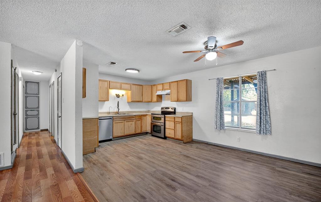 604 Fegan Street Weatherford, TX 76086 - Photo 16 of 36 a view of a kitchen with wooden floor and a window