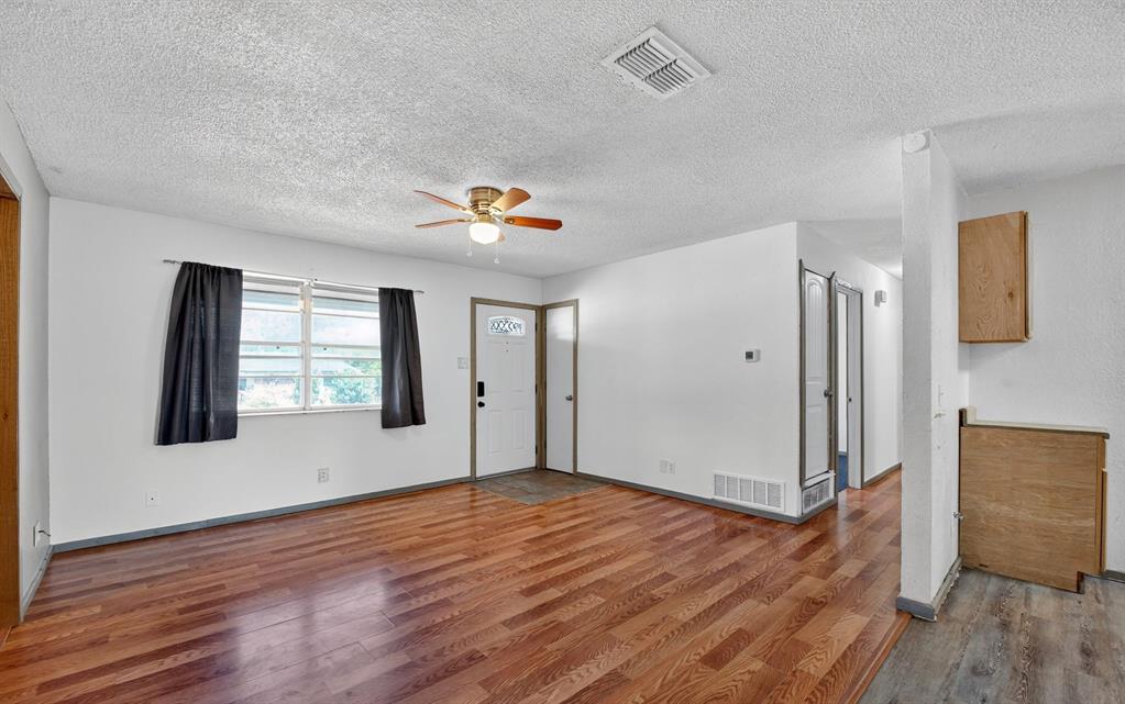 604 Fegan Street Weatherford, TX 76086 - Photo 6 of 36 a view of an empty room with wooden floor and a window
