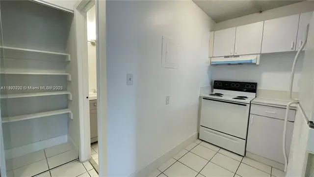 a kitchen with white cabinets and white appliances