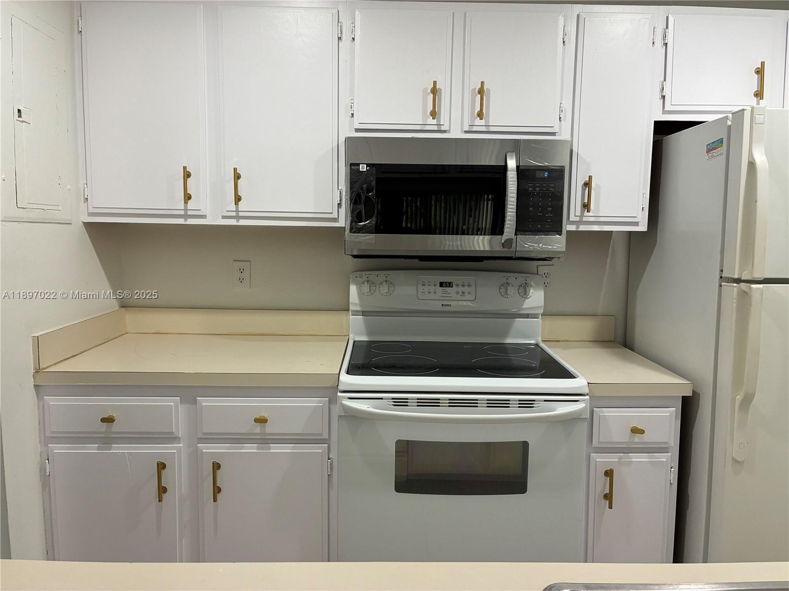 4091 Sierra Terrace, Unit 4091 Sunrise, FL 33351 - Photo 24 of 24 a kitchen with a stove and a microwave