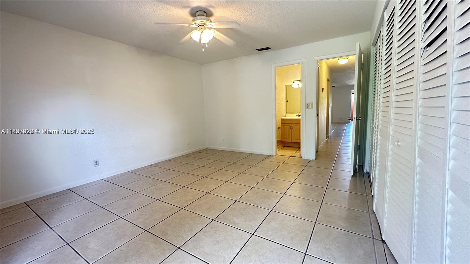 4091 Sierra Terrace, Unit 4091 Sunrise, FL 33351 - Photo 7 of 24 an empty room with closet and a chandelier fan