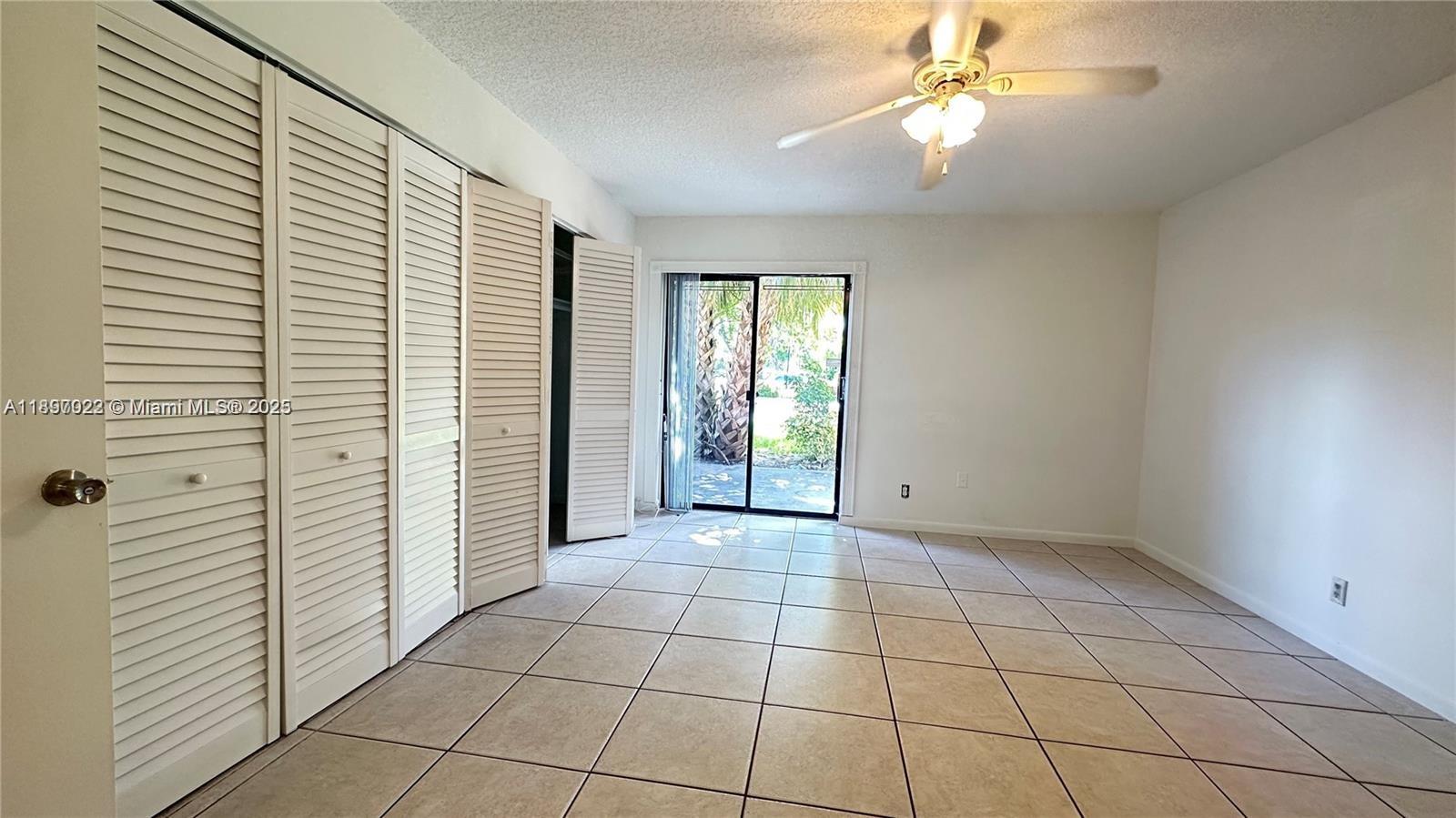 4091 Sierra Terrace, Unit 4091 Sunrise, FL 33351 - Photo 8 of 24 an empty room with windows and ceiling fan