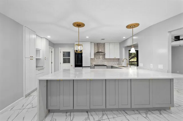 a kitchen with stainless steel appliances kitchen island granite countertop a sink a stove and cabinets