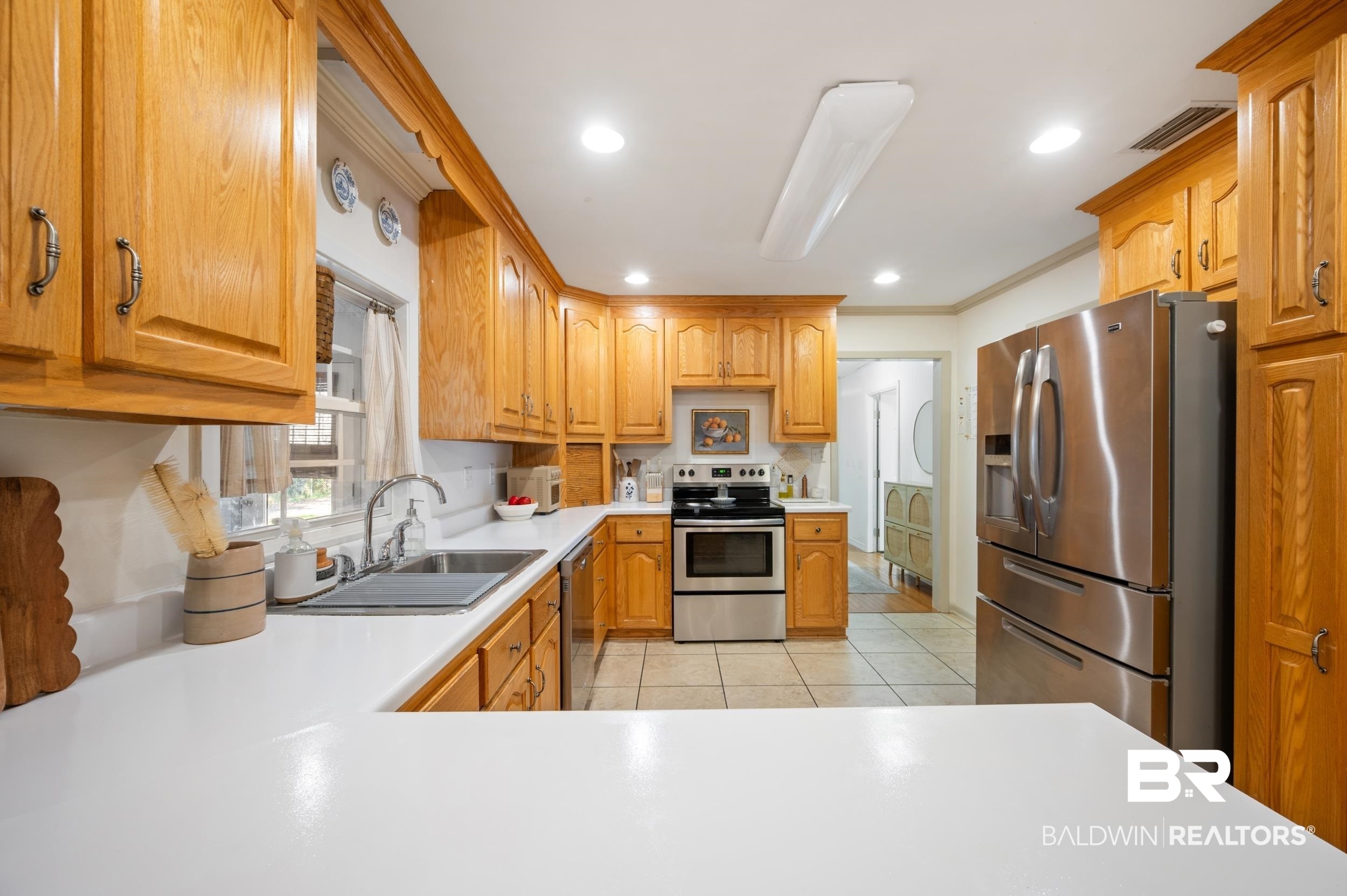 809 Moog Avenue Bay Minette, AL 36507 - Photo 12 of 33 Kitchen featuring stainless steel appliances, light countertops, light tile patterned floors, recessed lighting, and crown molding