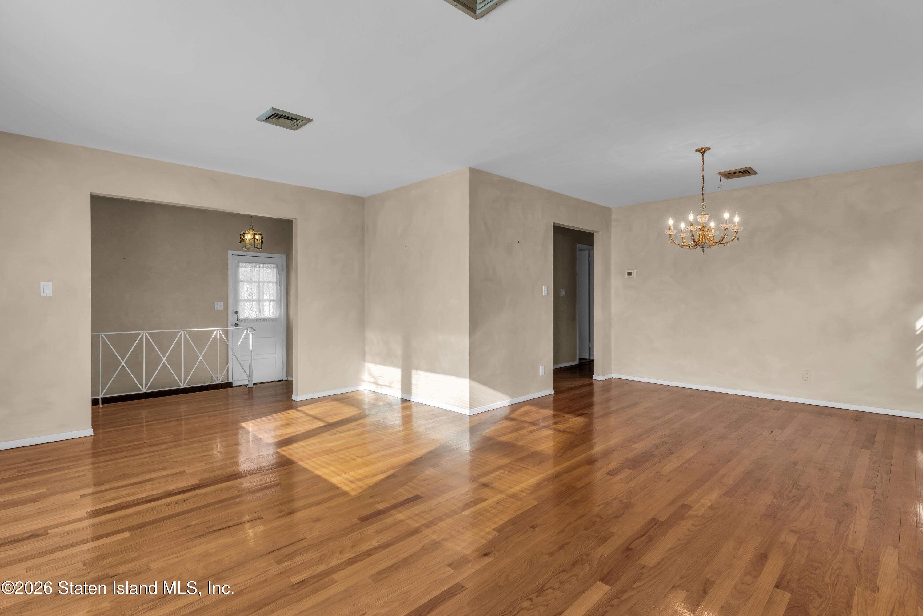 203 Wolverine Street Staten Island, NY 10306 - Photo 11 of 26 an empty room with wooden floor and mirror
