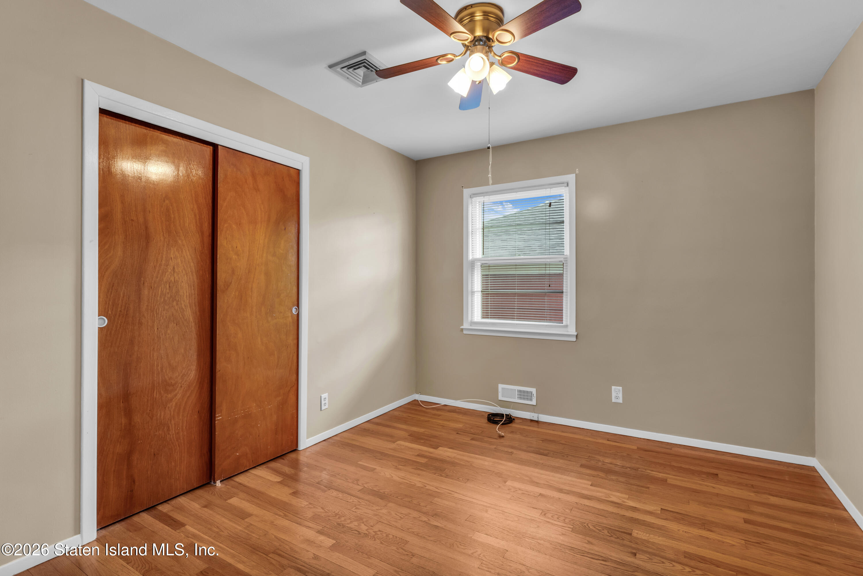 203 Wolverine Street Staten Island, NY 10306 - Photo 13 of 26 an empty room with wooden floor closet and windows
