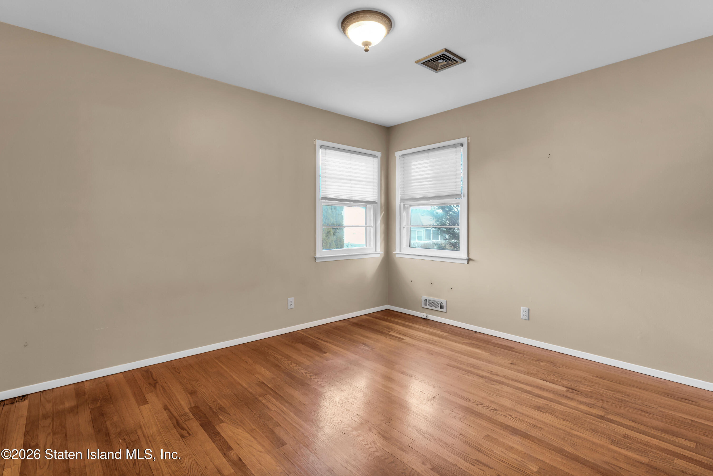 203 Wolverine Street Staten Island, NY 10306 - Photo 15 of 26 an empty room with wooden floor and windows