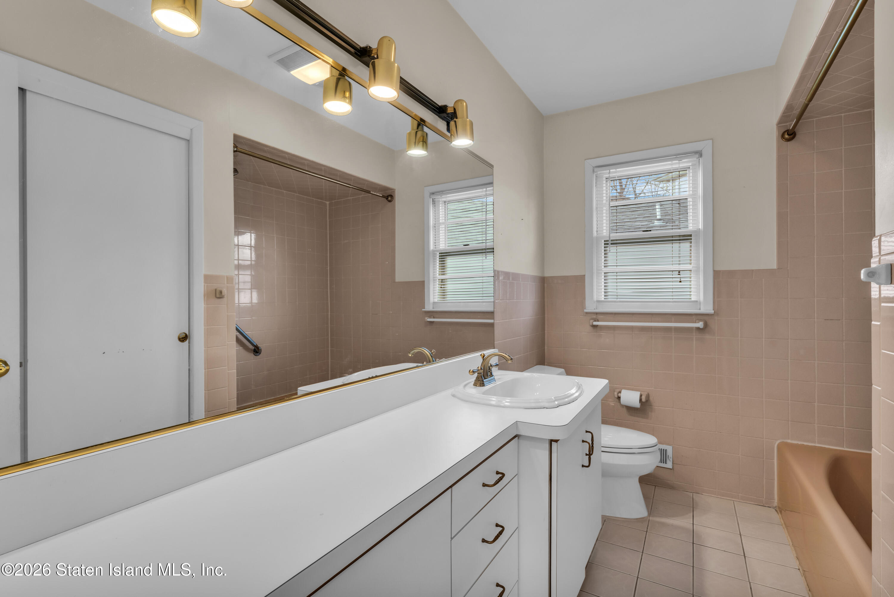 203 Wolverine Street Staten Island, NY 10306 - Photo 18 of 26 a bathroom with a sink a toilet and a mirror