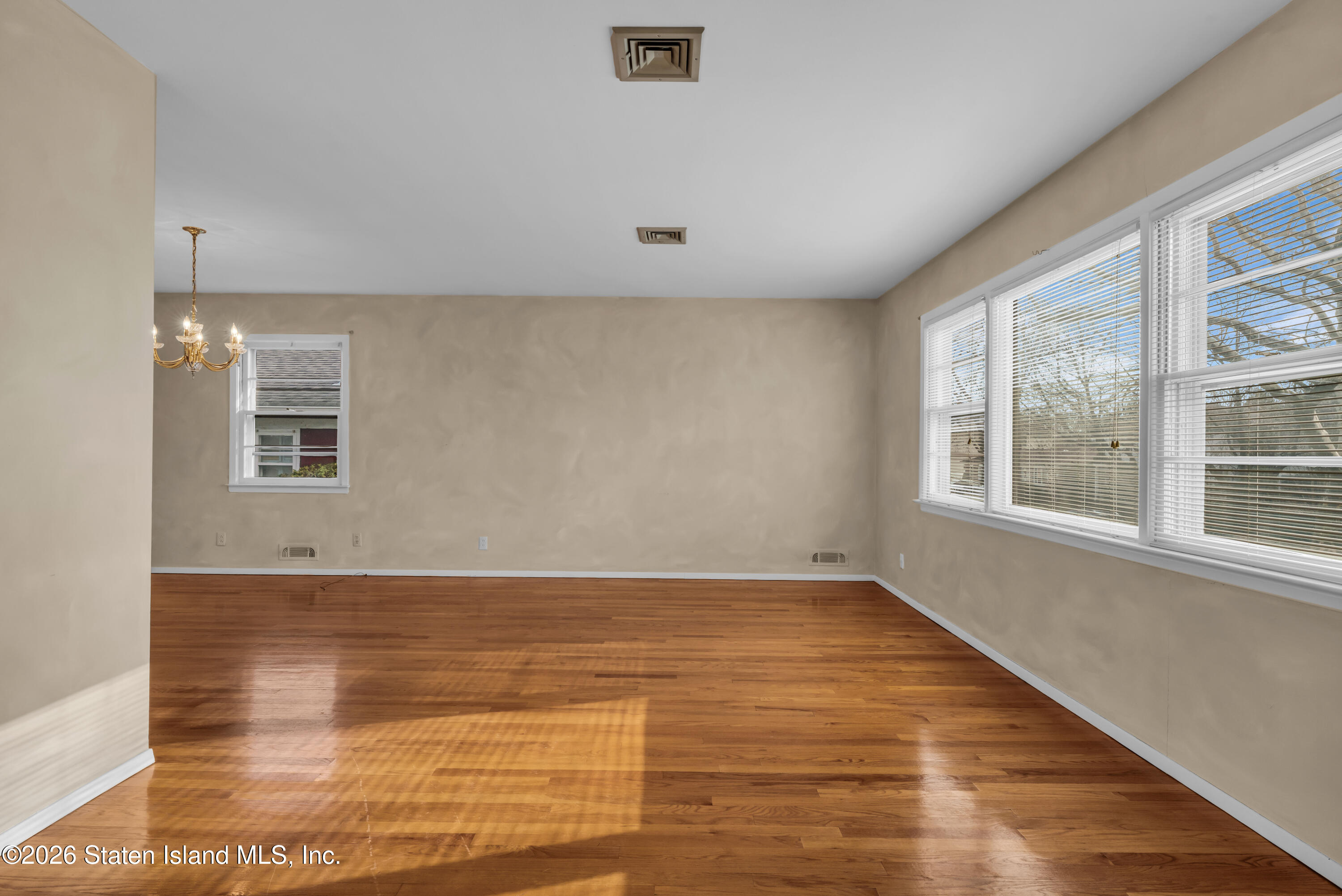 203 Wolverine Street Staten Island, NY 10306 - Photo 8 of 26 a view of empty room with wooden floor and fan