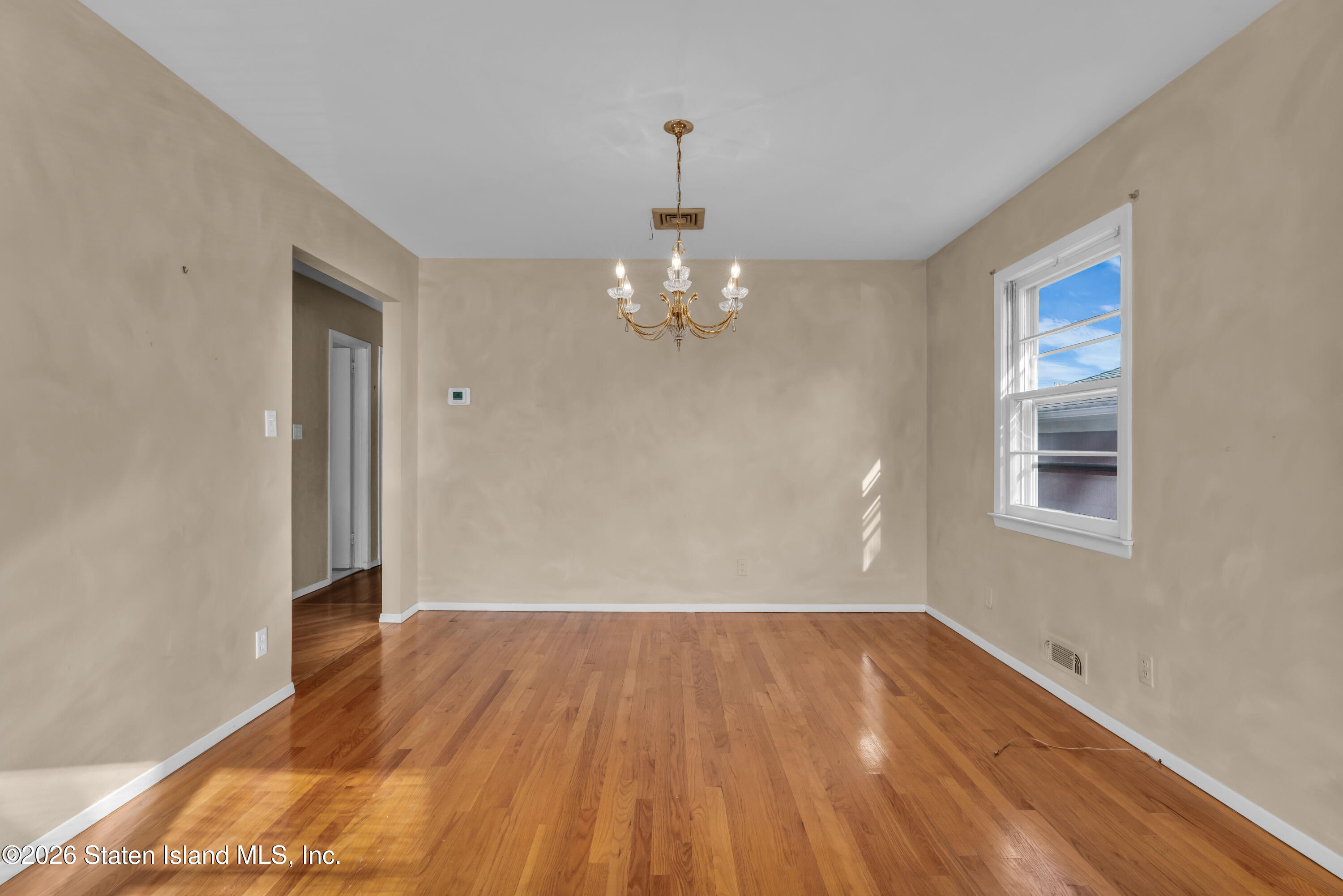 203 Wolverine Street Staten Island, NY 10306 - Photo 10 of 26 a view of a room with wooden floor and chandelier