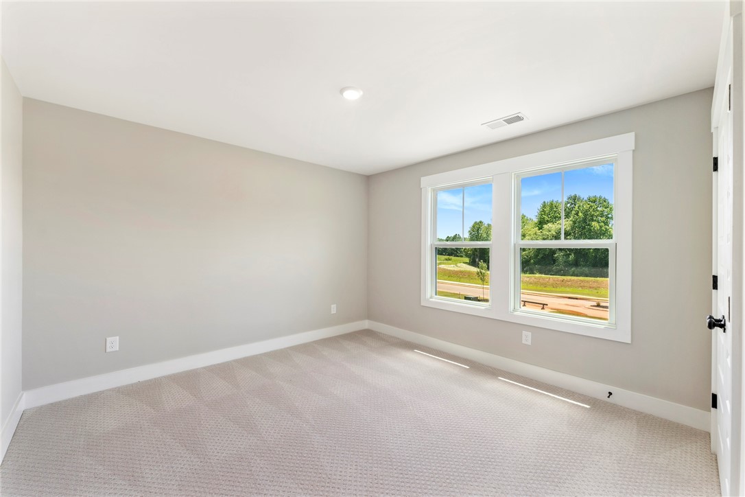133 Osprey Landing Central, SC 29630 - Photo 21 of 34 This bright and airy room features generous windows overlooking scenic views, offering a comfortable living space.