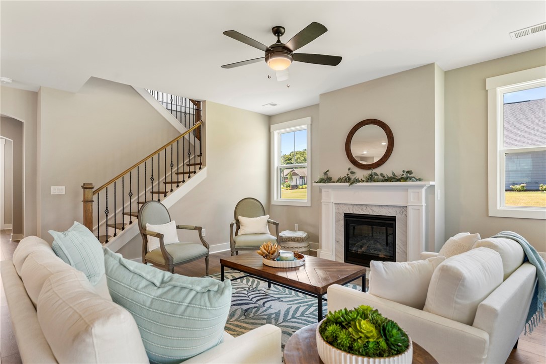 133 Osprey Landing Central, SC 29630 - Photo 8 of 34 Bright and airy living room with a cozy fireplace and convenient staircase access.
