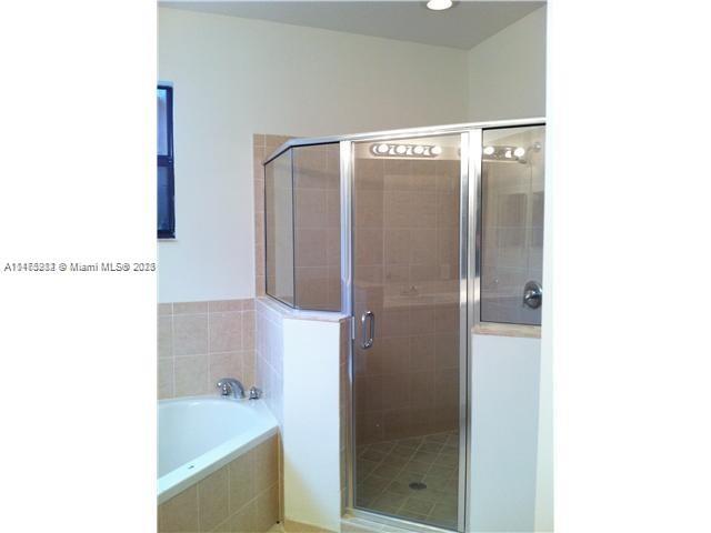 11459 Southwest 238th Street, Unit 11459 Homestead, FL 33032 - Photo 9 of 12 a bathroom with a bathtub and a sink