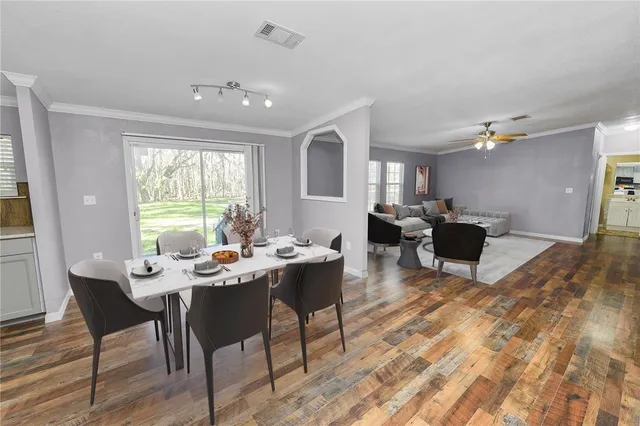 a view of an empty room with window and wooden floor