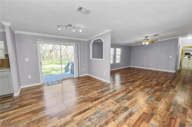 a view of a livingroom with wooden floor and a ceiling fan