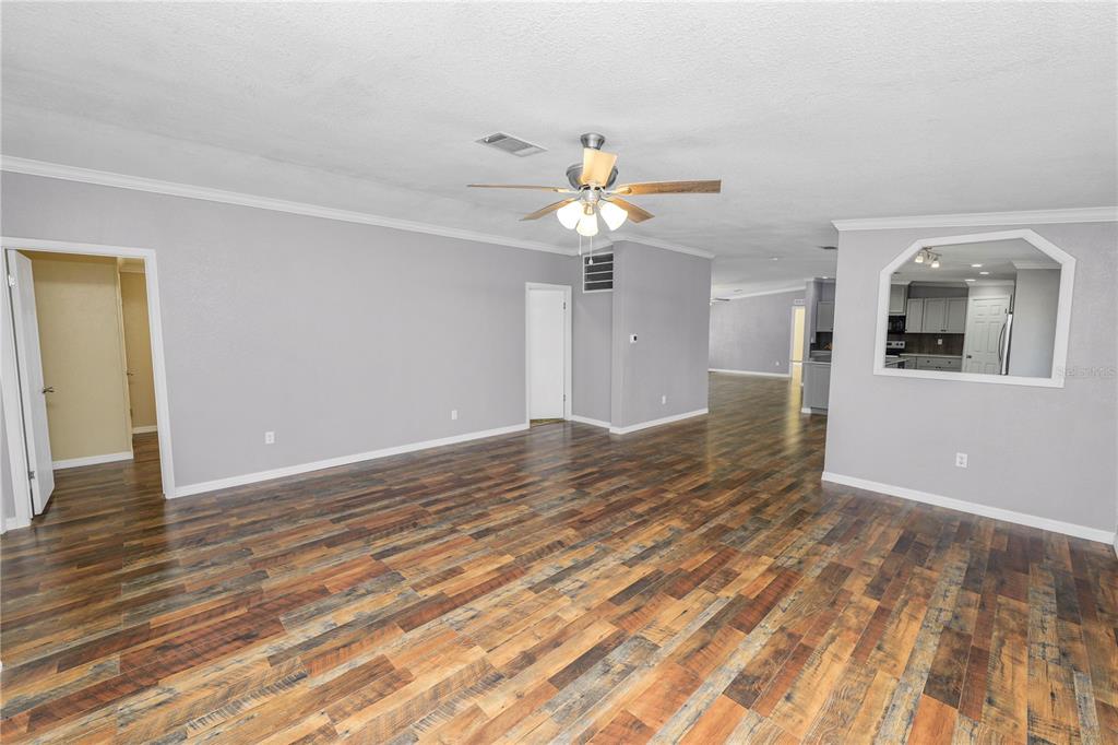 7405 Shoupe Road Plant City, FL 33565 - Photo 17 of 61 a view of an empty room with wooden floor and a ceiling fan