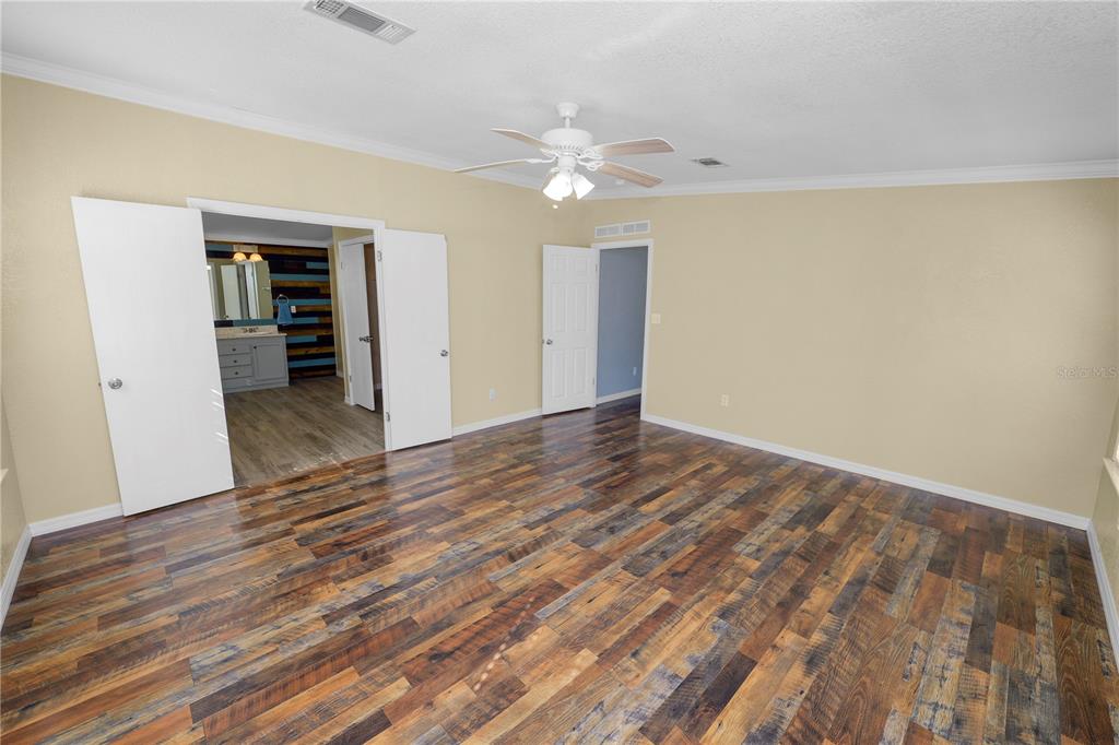 7405 Shoupe Road Plant City, FL 33565 - Photo 26 of 61 a view of a livingroom with wooden floor and a ceiling fan